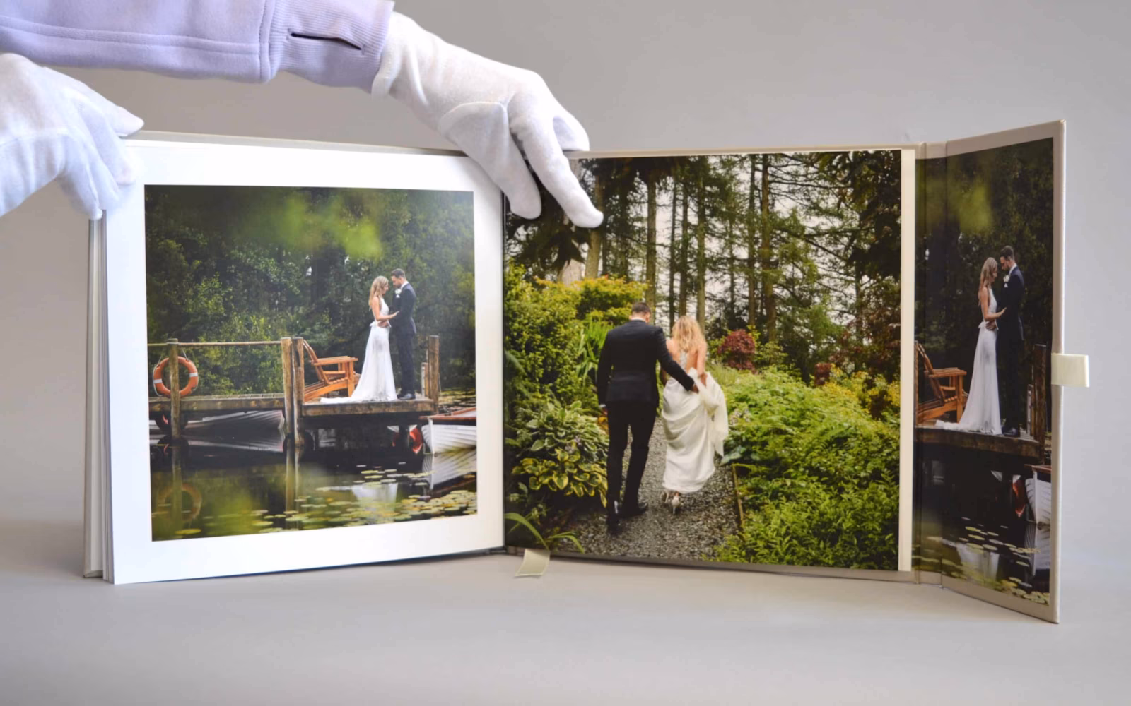 Wedding album open to photographs of a couple beside a lake