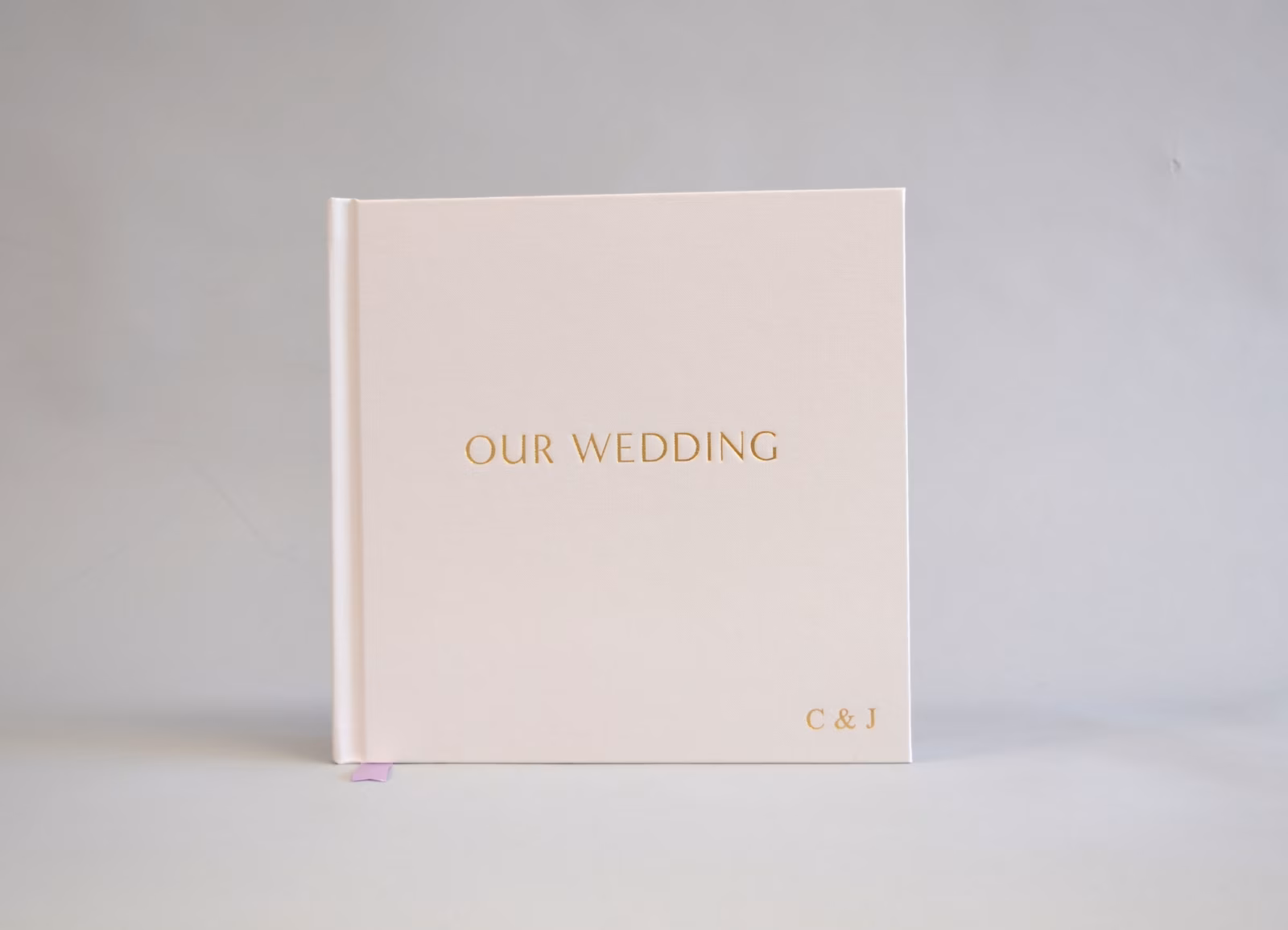 Ivory wedding album with a gold-foiled title and initials
