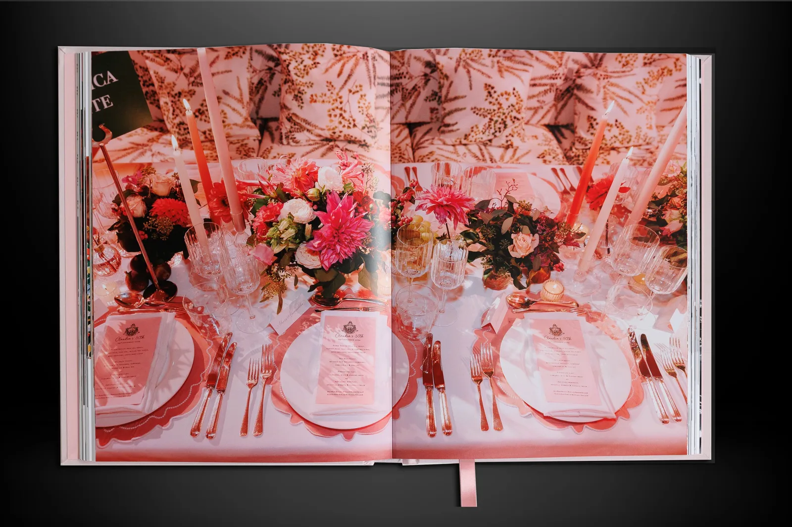 Lay-flat wedding album opened across a formal reception table setting