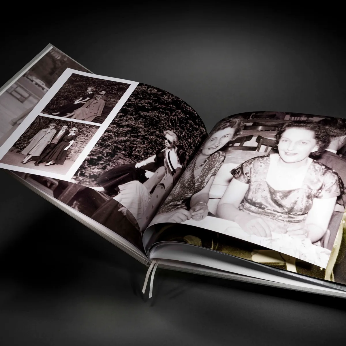 Family history book open across restored archive photographs