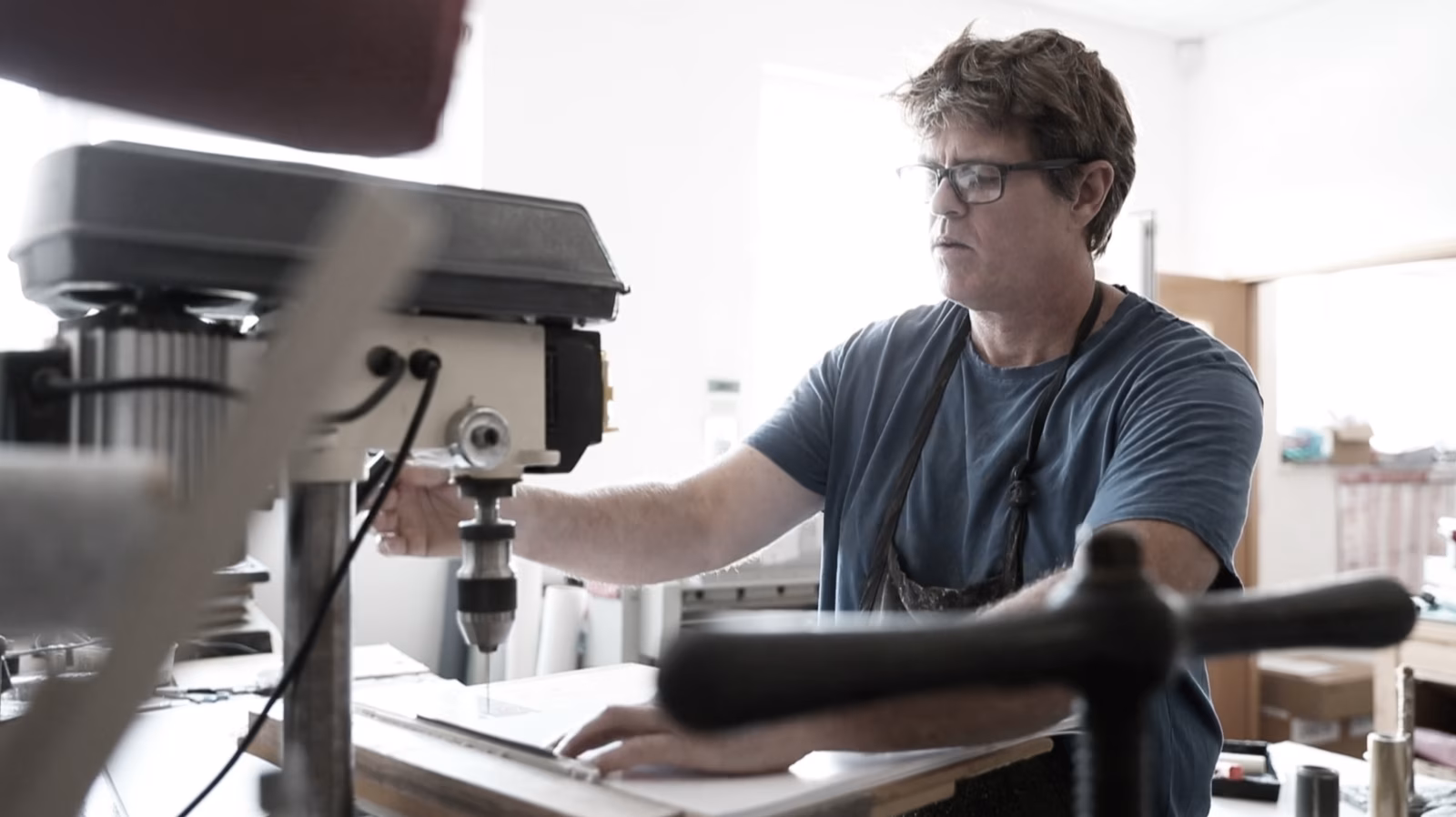 A person working at the drill in the Booked Images bindery