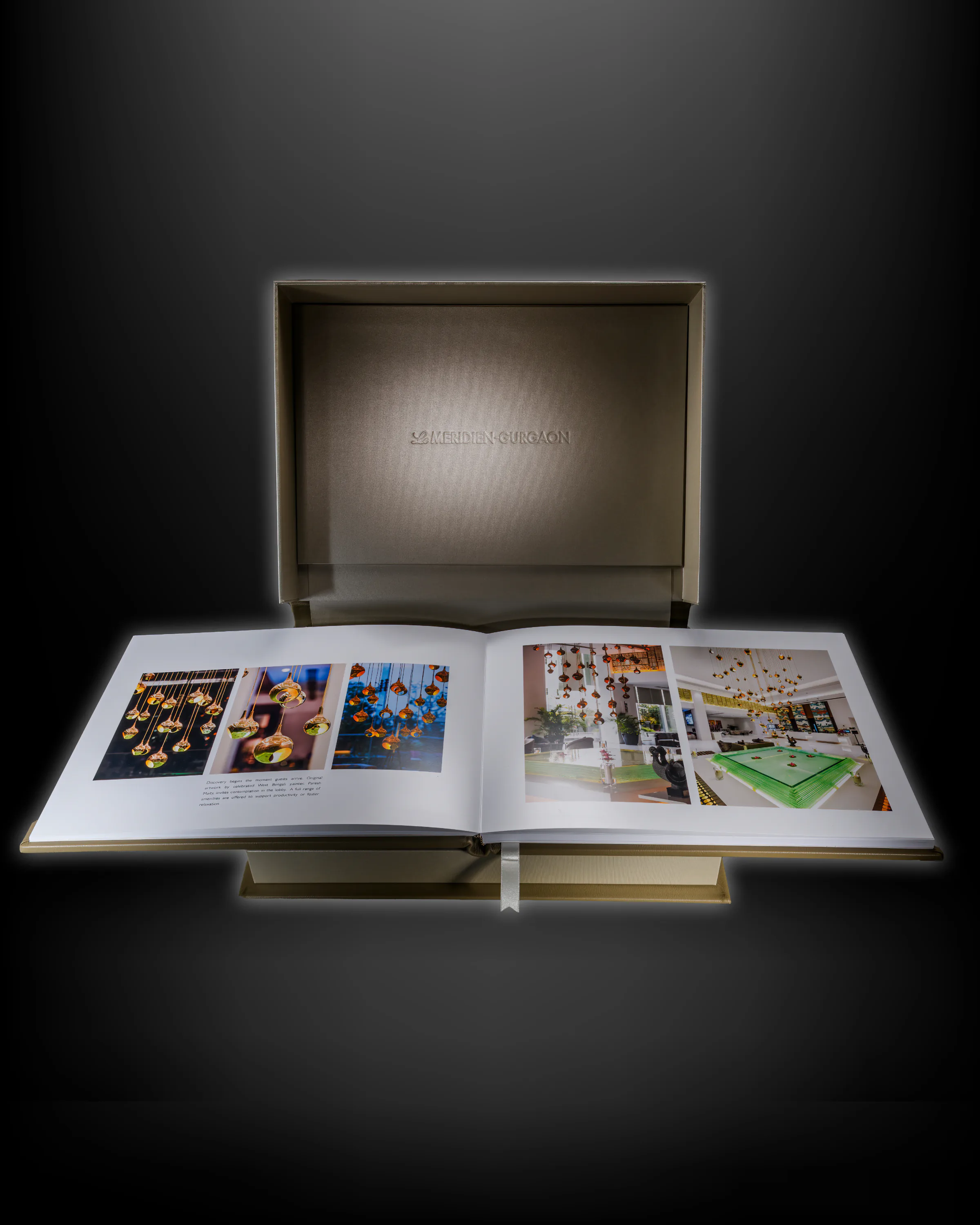 Corporate heritage book opened to event photographs inside a presentation box