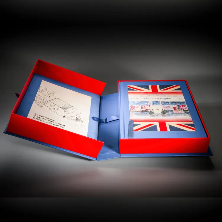 Red and blue company heritage book displayed with a Union Jack presentation box