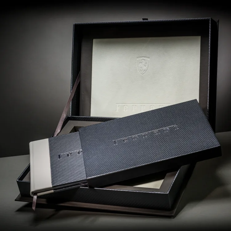 Ferrari books arranged inside a matching carbon-fibre presentation box