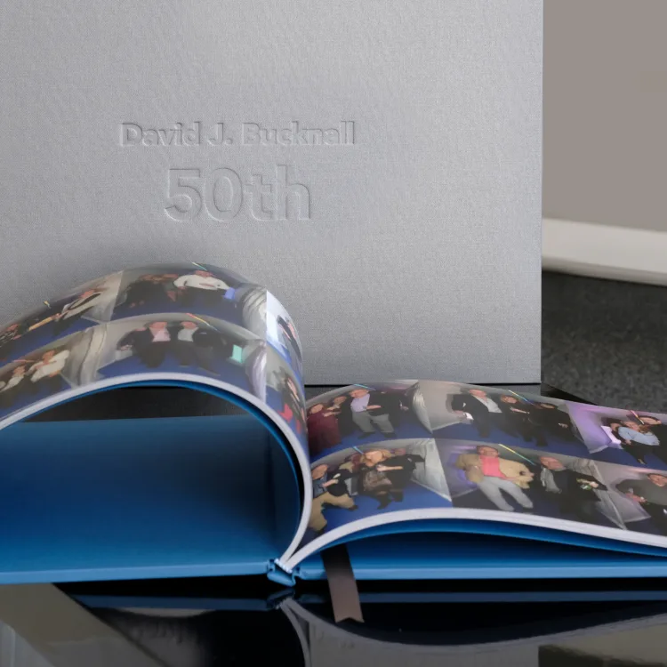 Fiftieth birthday family photo book open beside its personalised presentation box