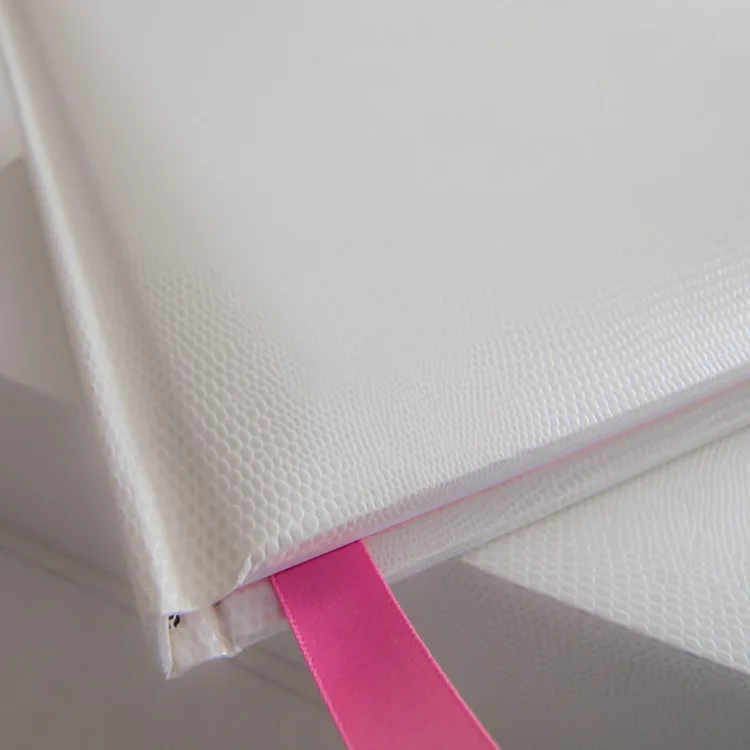 Detail of a white textured family album with a pink ribbon marker