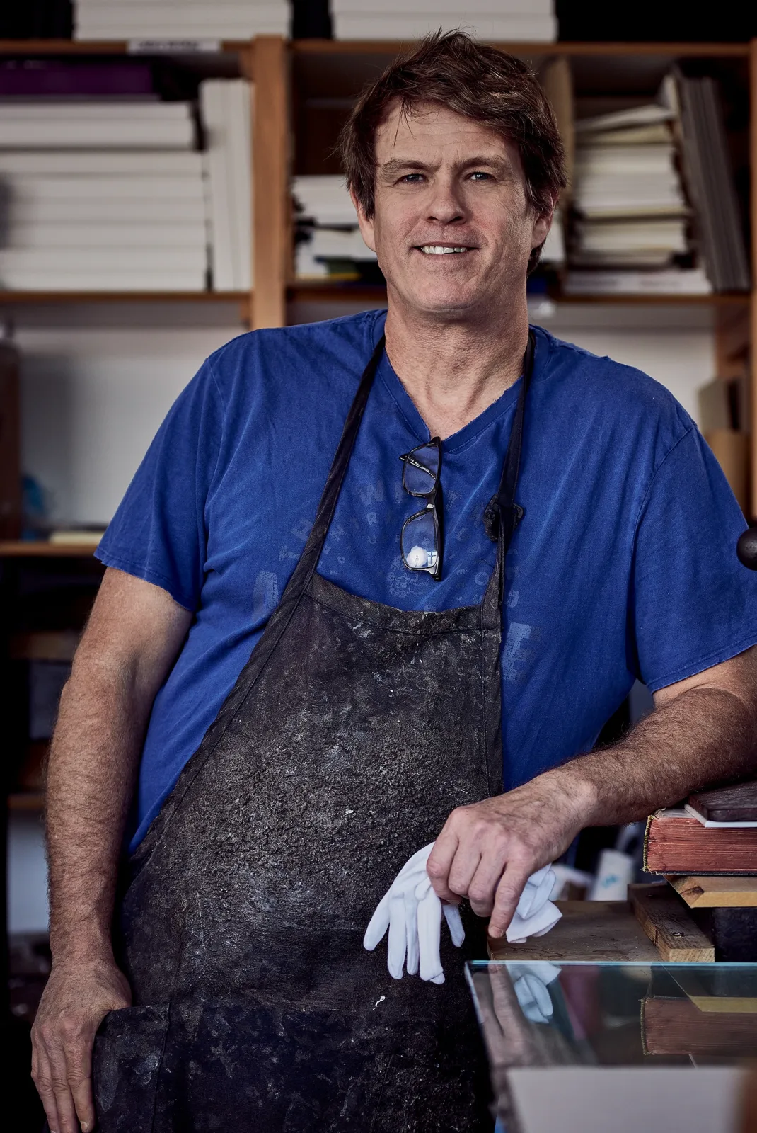 Frank, Master Bookbinder, seated at his workbench in the Booked Images bindery