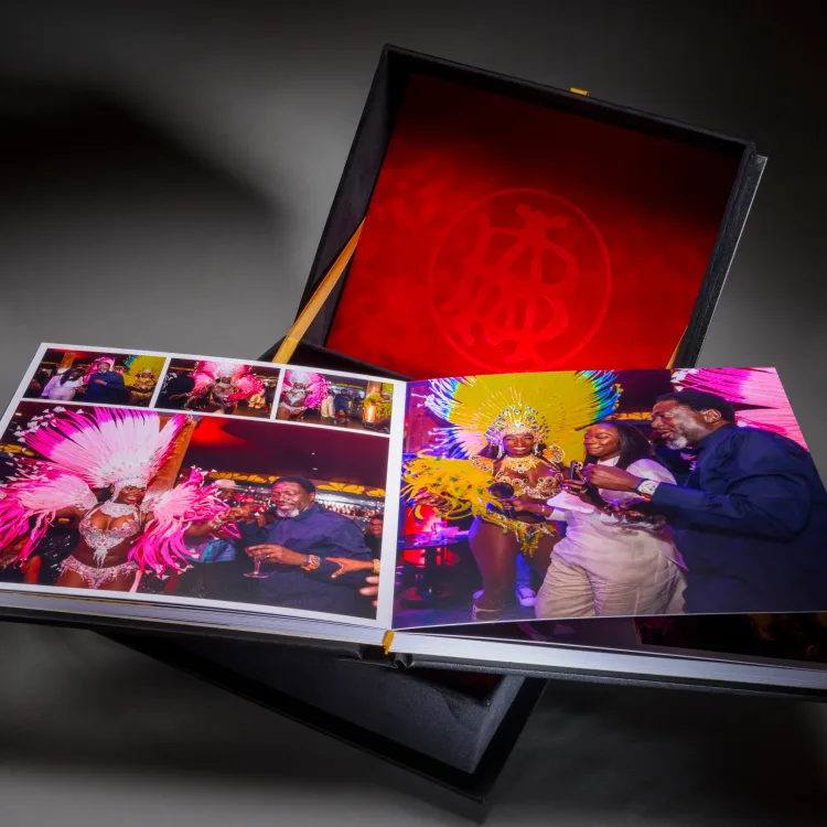 Fiftieth birthday photo album opened to colourful party photographs
