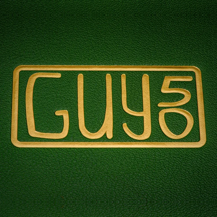 Close-up of a gold monogram embossed into green book cloth