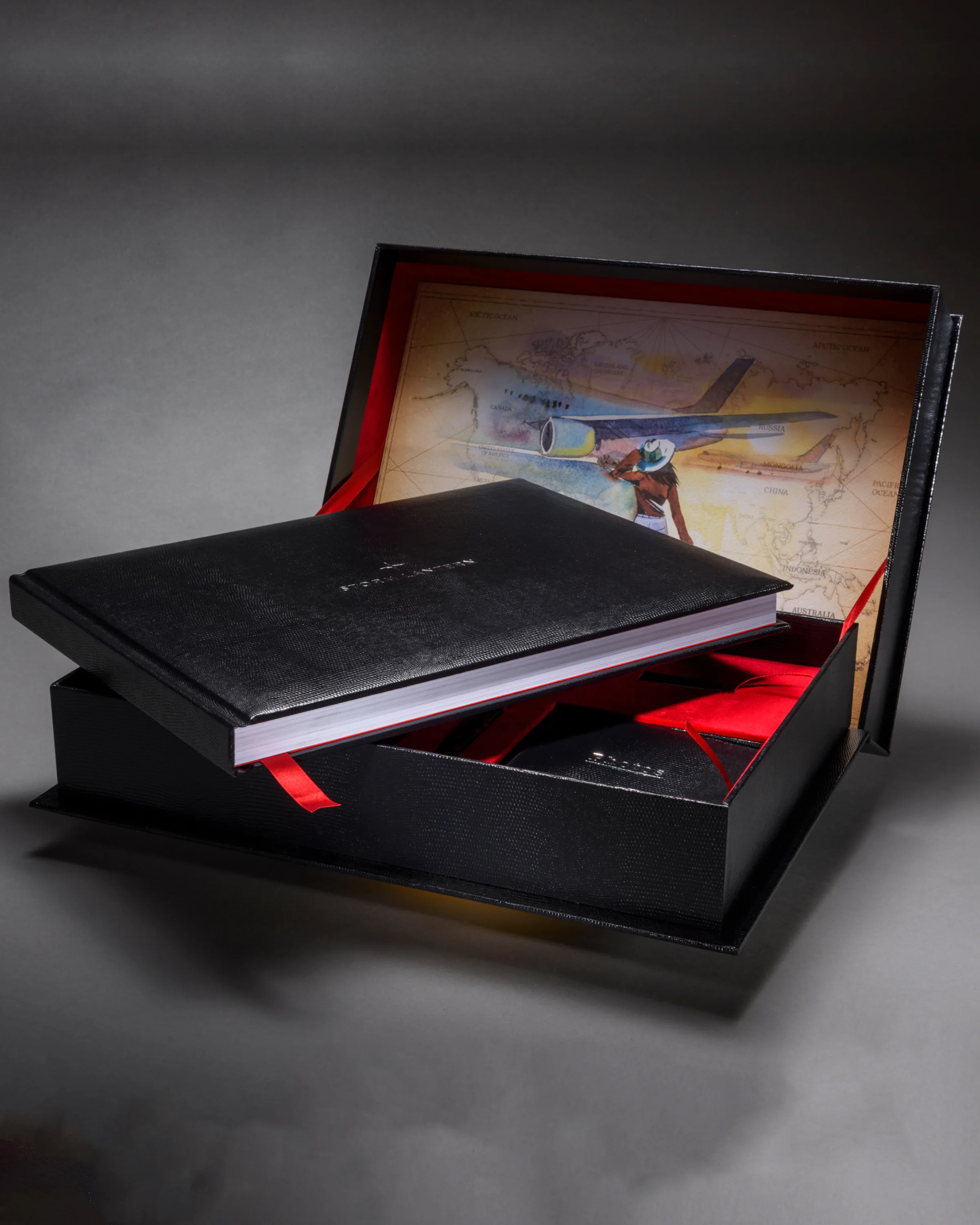 Black travel journal presented in a box lined with an illustrated world map