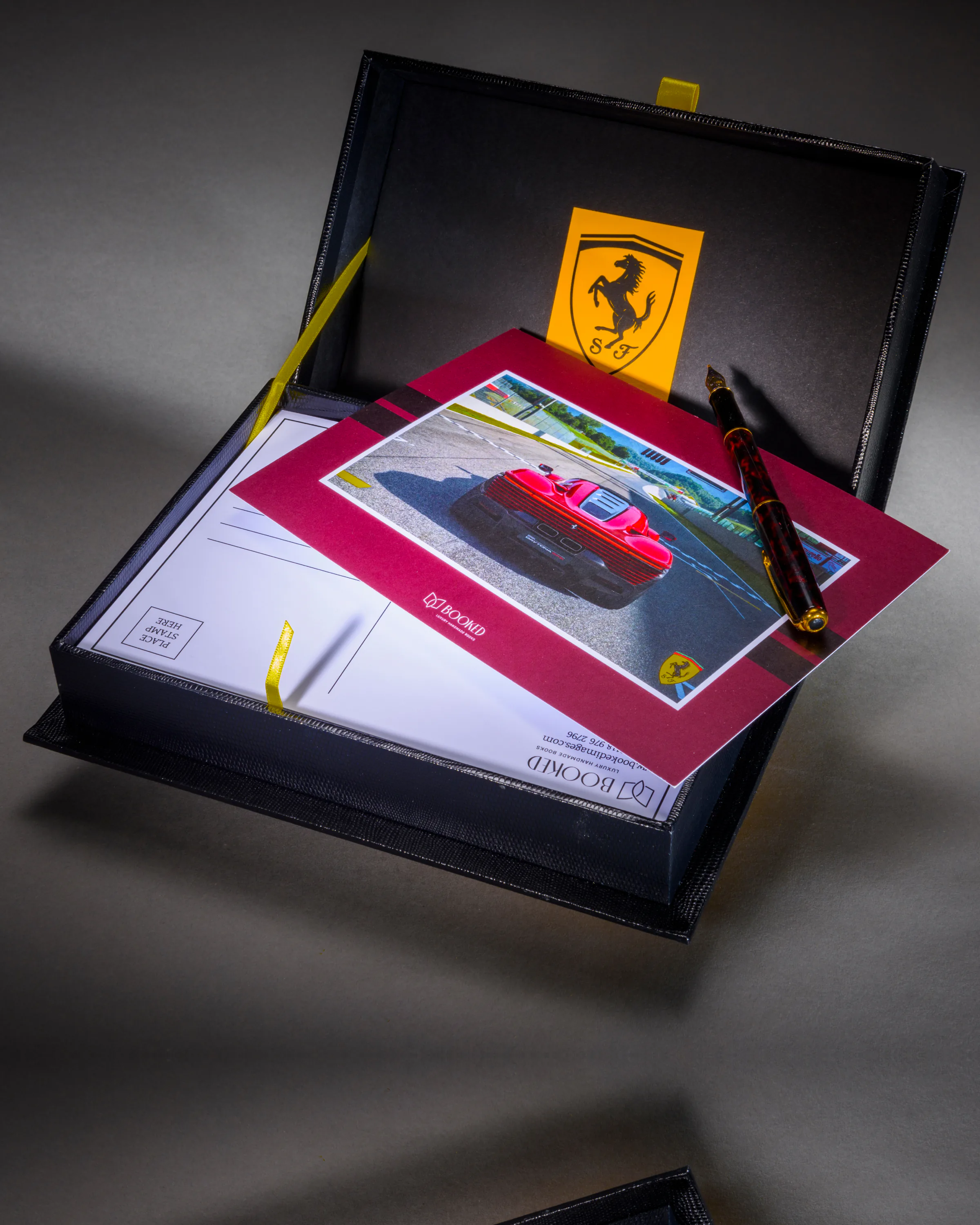 Ferrari motorsport book and keepsakes arranged in a bespoke black gift box