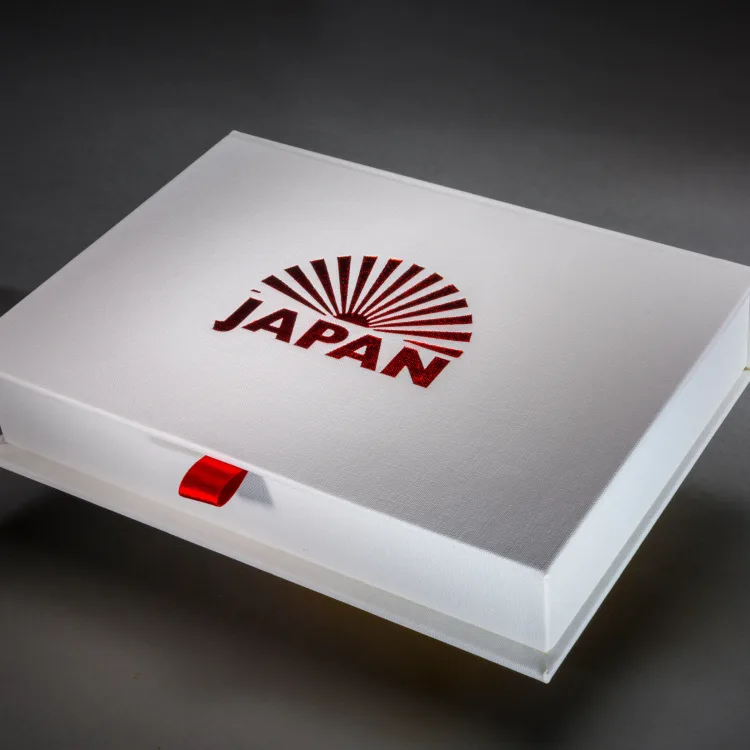 White Japan travel book presentation box with a red foiled title and ribbon pull