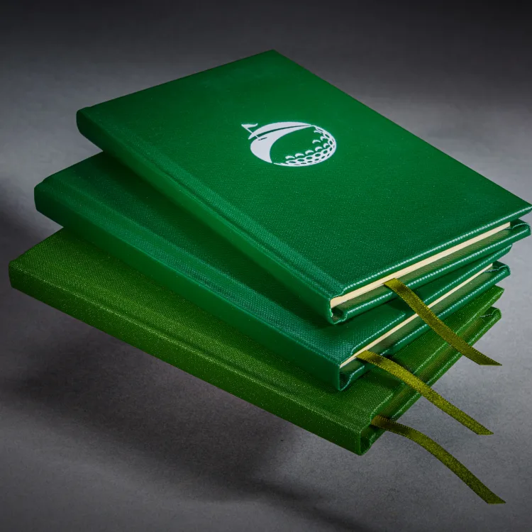 Stack of personalised green golf books finished with gold ribbon markers