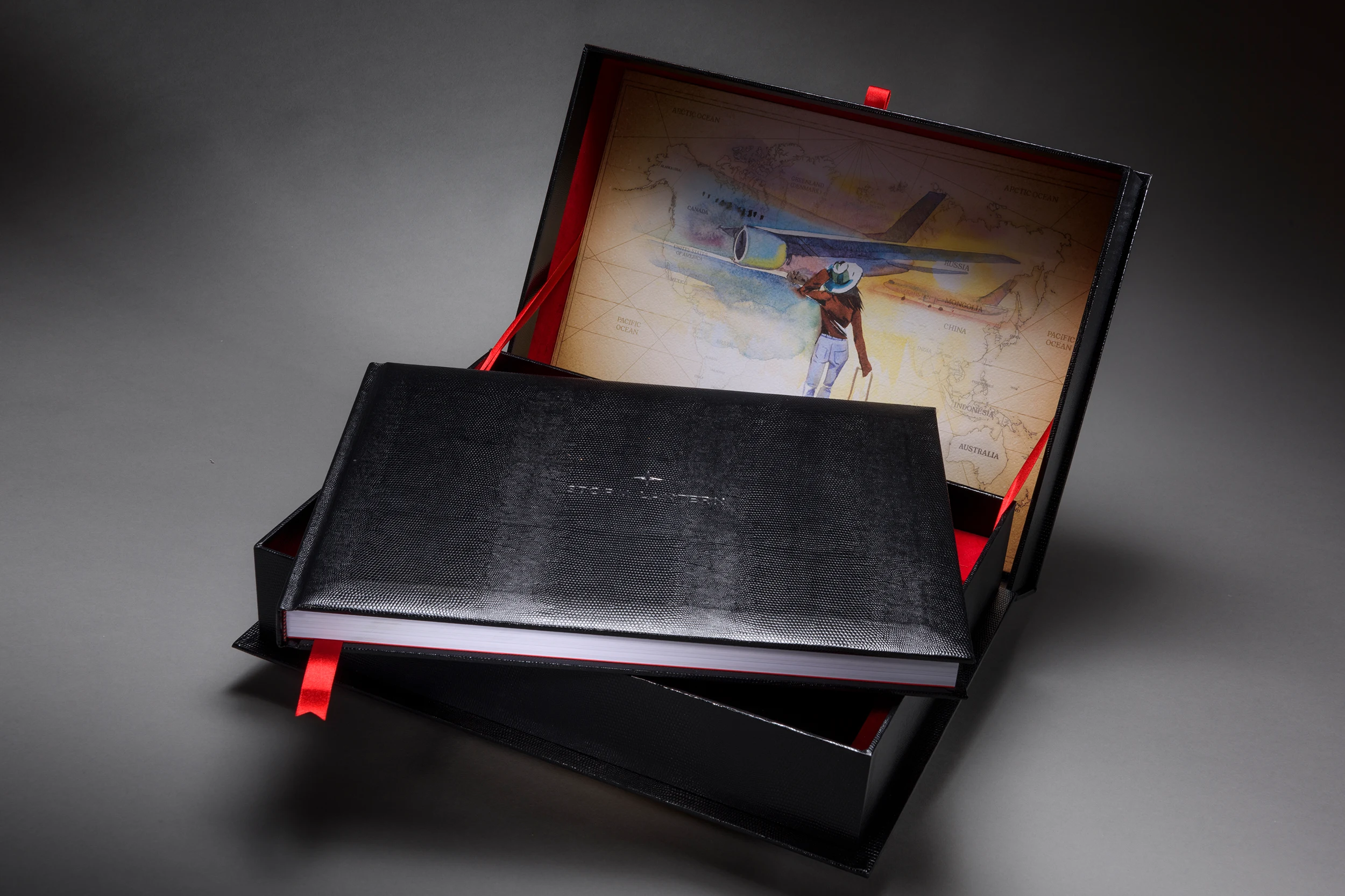 Black polo art book beside its matching presentation box