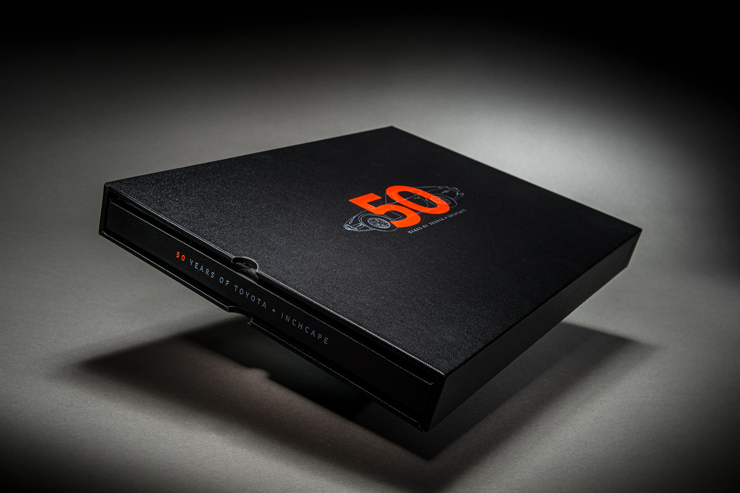 Black Toyota 50th anniversary book with an embossed cover