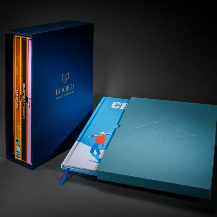 Colourful adventure travel books arranged with a bespoke blue slipcase