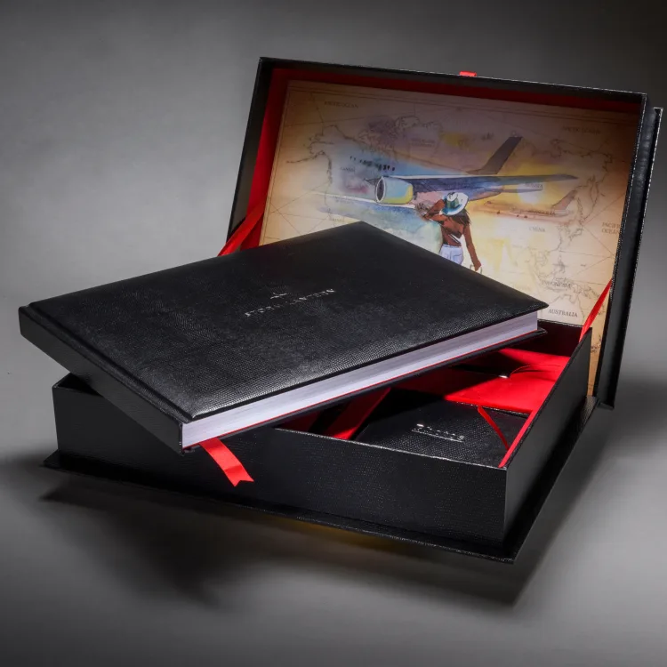 Black travel journal presented in a box lined with an illustrated world map