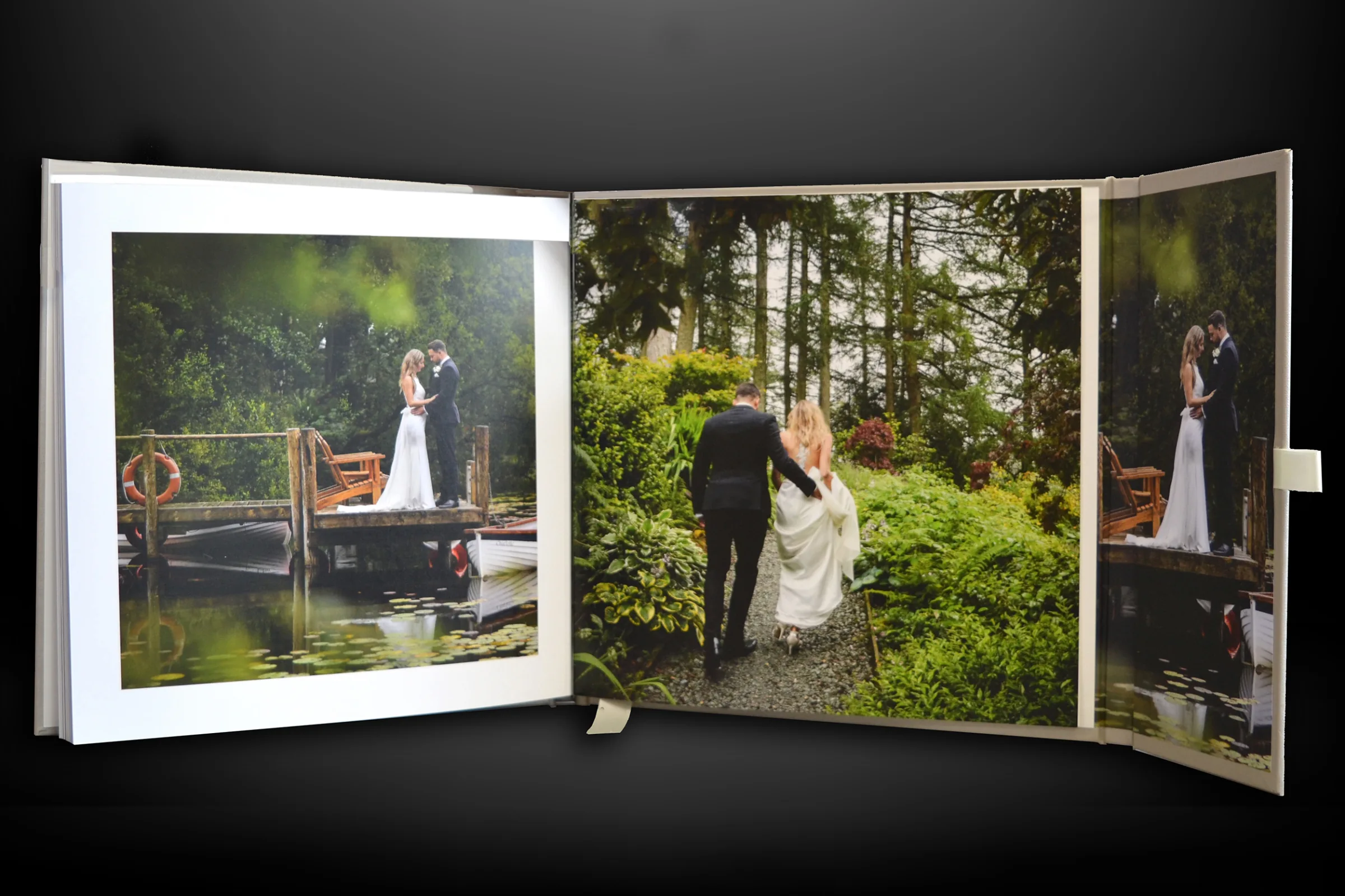 Open wedding album displaying portraits of the couple across a double-page spread