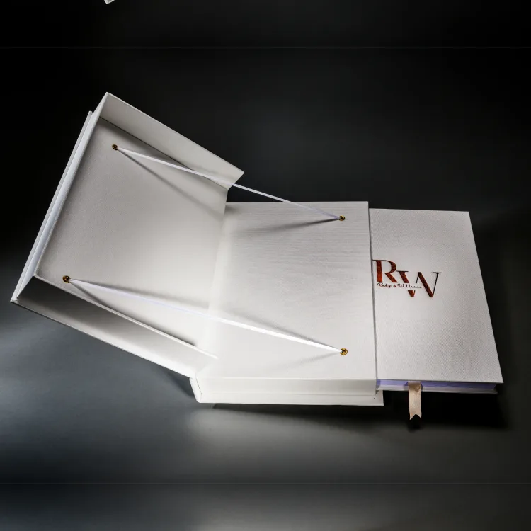White R and W wedding album beside an open clamshell presentation box