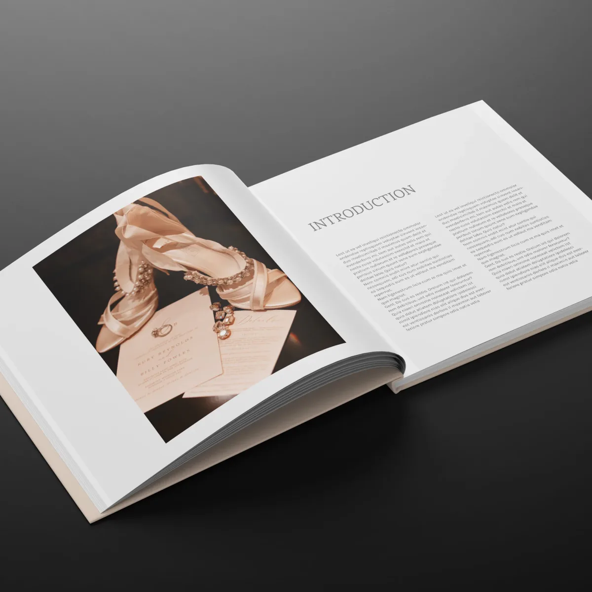 Open wedding photo book pairing a photograph of bridal shoes and invitations with an introduction page